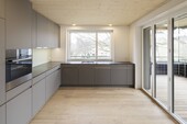 Insight into the kitchen with visible wooden ceiling (Photos: ©kämpfen für architektur ag, Zurich)